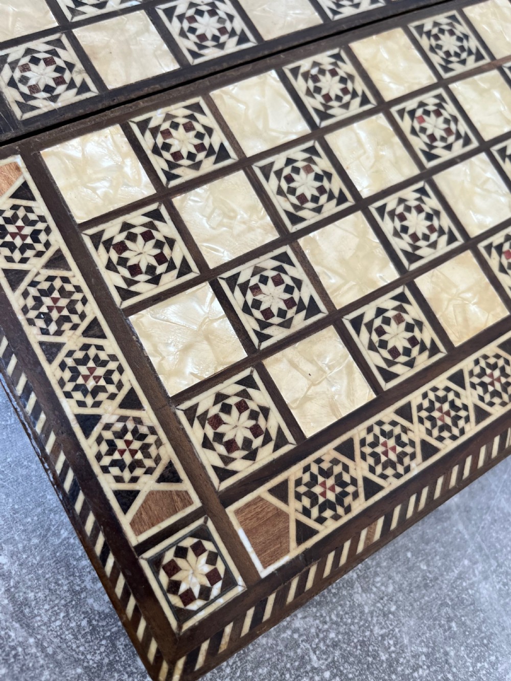 A hinged wooden folding games board featuring intricate geometric micro-mosaic marquetry and mother-of-pearl star motifs. View V
