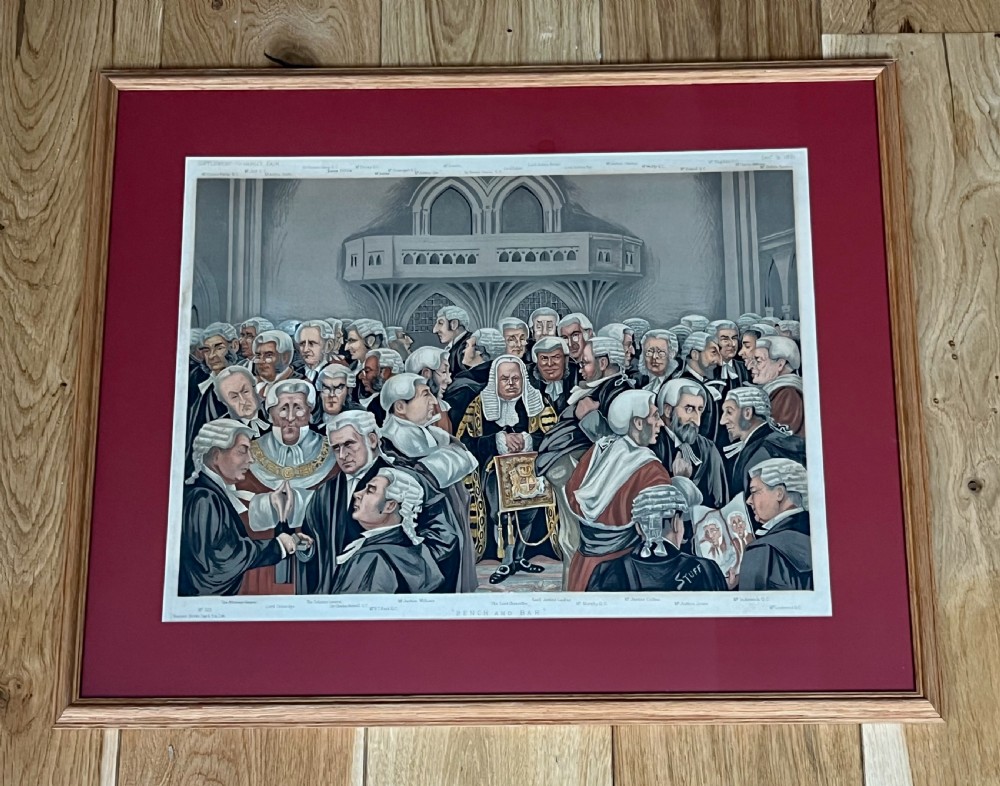 A framed late Victorian lithographic print entitled Bench and Bar featuring a crowd of barristers and judges in traditional wigs and gowns framed in light wood with a burgundy mount.