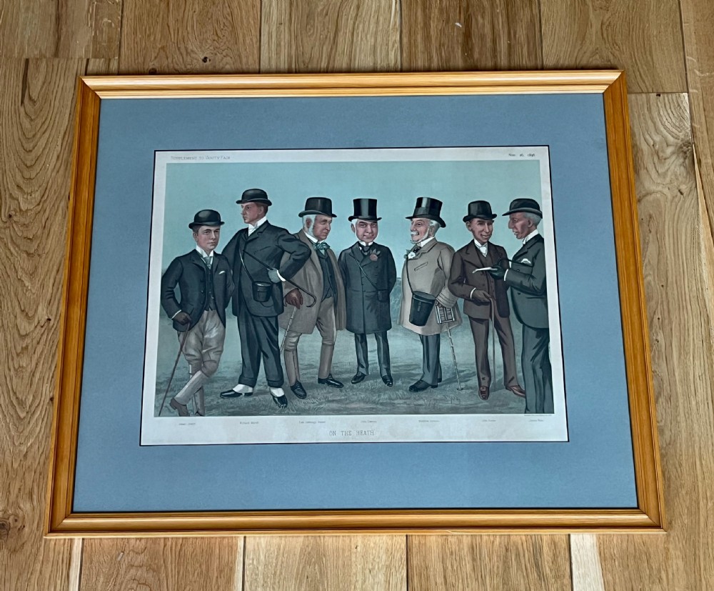 A Victorian framed Vanity Fair chromolithograph print titled Newmarket 1885 depicting an equestrian caricature scene inside a dark green mount and light wood frame. View IV
