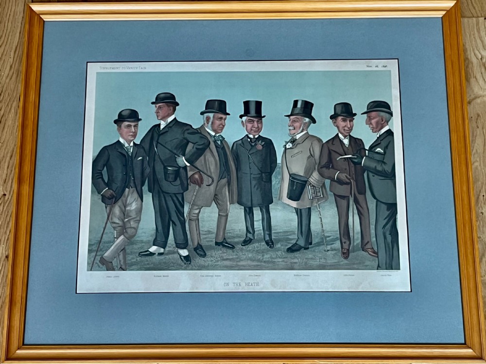 A Victorian framed Vanity Fair chromolithograph print titled Newmarket 1885 depicting an equestrian caricature scene inside a dark green mount and light wood frame. View V