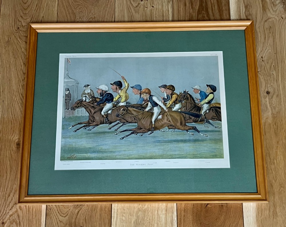 A Victorian framed Vanity Fair chromolithograph print titled Newmarket 1885 depicting an equestrian caricature scene inside a dark green mount and light wood frame. View X