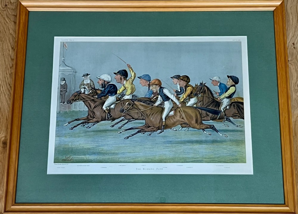 A Victorian framed Vanity Fair chromolithograph print titled Newmarket 1885 depicting an equestrian caricature scene inside a dark green mount and light wood frame. View XII