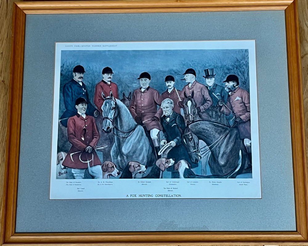 A framed Vanity Fair colour lithograph depicting five gentlemen in traditional red hunting attire set against a blue backdrop within a green card mount and simple wooden frame. View VIII