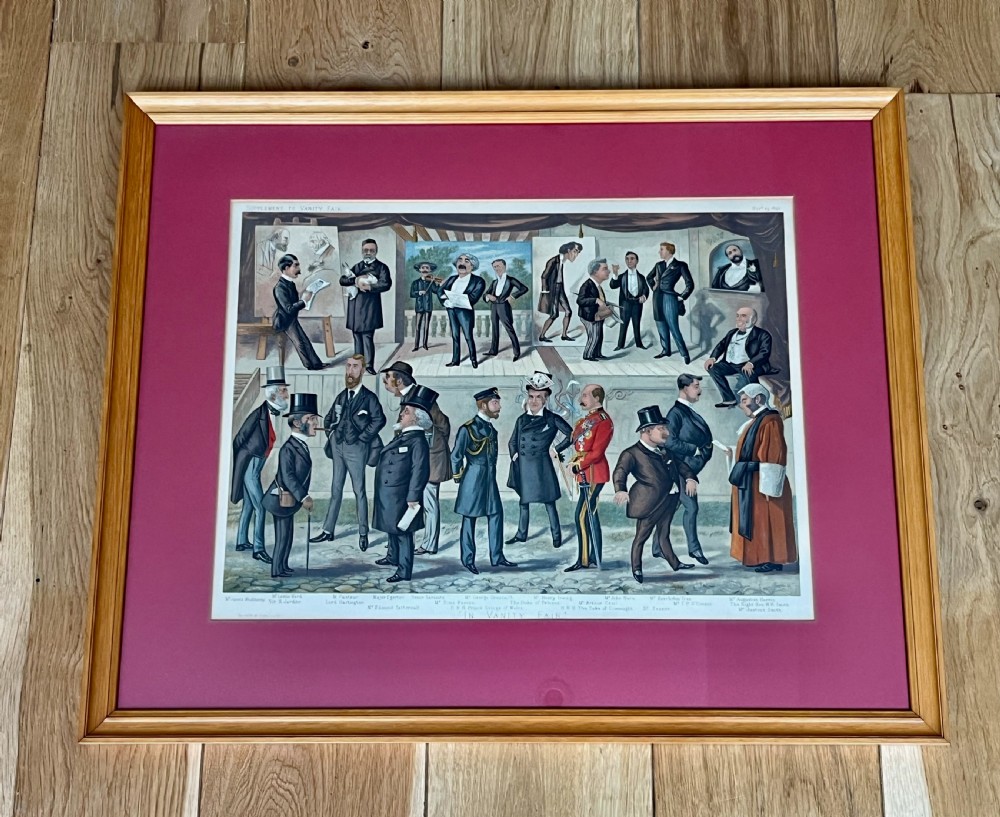 A framed Victorian Vanity Fair chromolithograph featuring group caricatures of late nineteenth-century figures, presented with a dark magenta mount and a light wood frame.