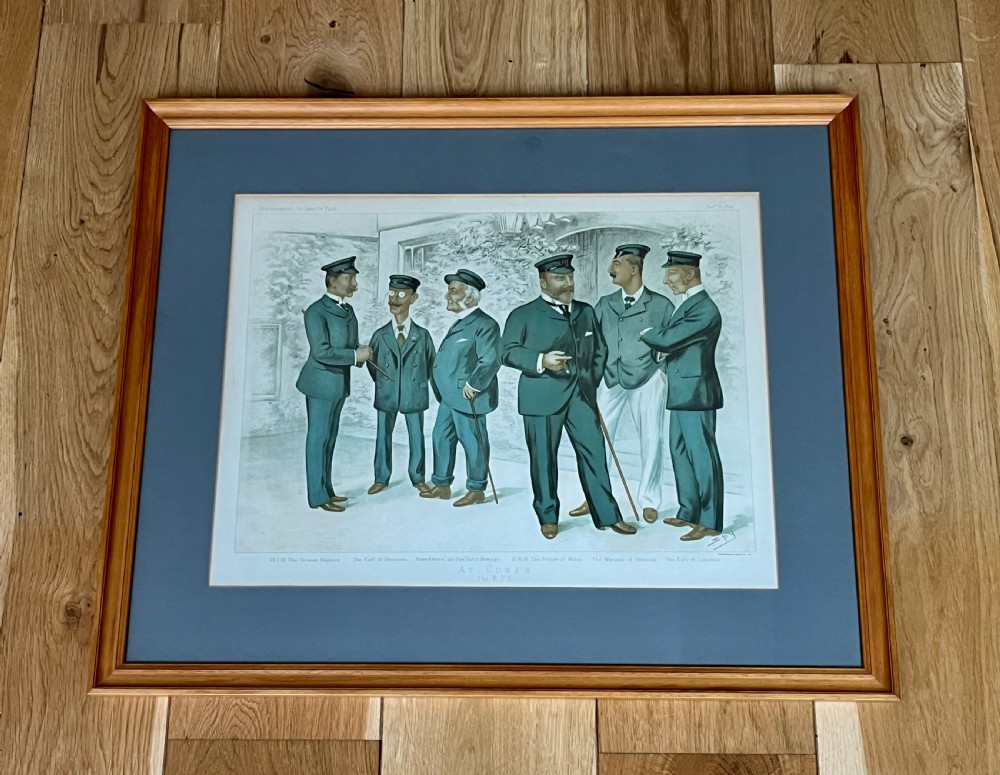 A framed Victorian Vanity Fair chromolithograph featuring group caricatures of late nineteenth-century figures, presented with a dark magenta mount and a light wood frame. View IV