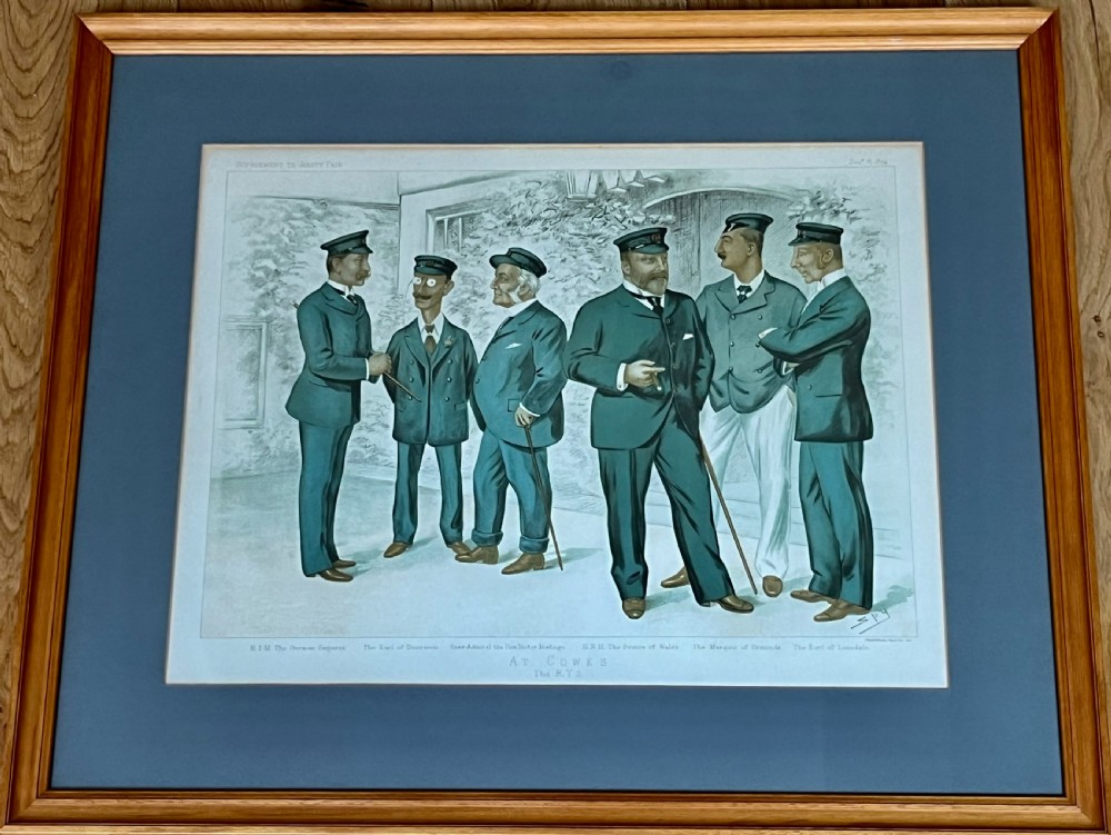 A framed Victorian Vanity Fair chromolithograph featuring group caricatures of late nineteenth-century figures, presented with a dark magenta mount and a light wood frame. View V