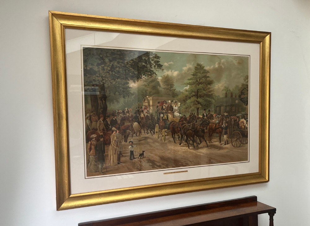 A framed 1885 colour lithograph titled The Meet of the Four-in-Hand Club depicting Victorian figures, horse-drawn carriages, and spectators in a park setting. View XI