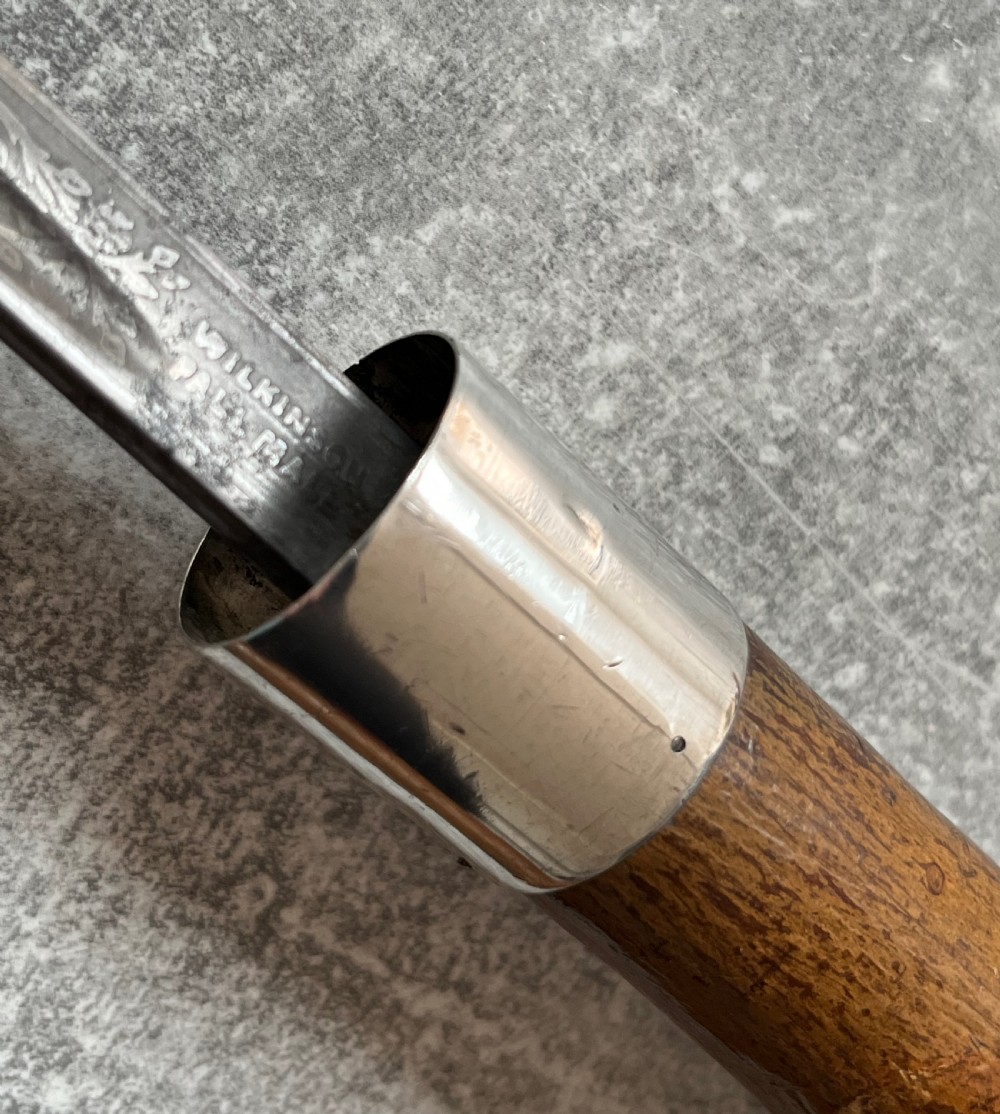 An antique chestnut wood sword stick shown unsheathed beside its shaft, featuring a root ball knob handle, silver collar mount, and long steel blade. View III