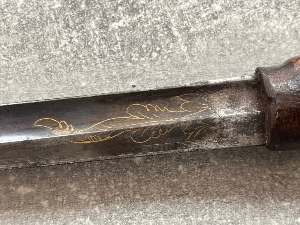 An antique sword stick with a dark brown leather-covered shaft, a silver knop top, and a partially drawn steel blade decorated with gold-toned etchings. View V