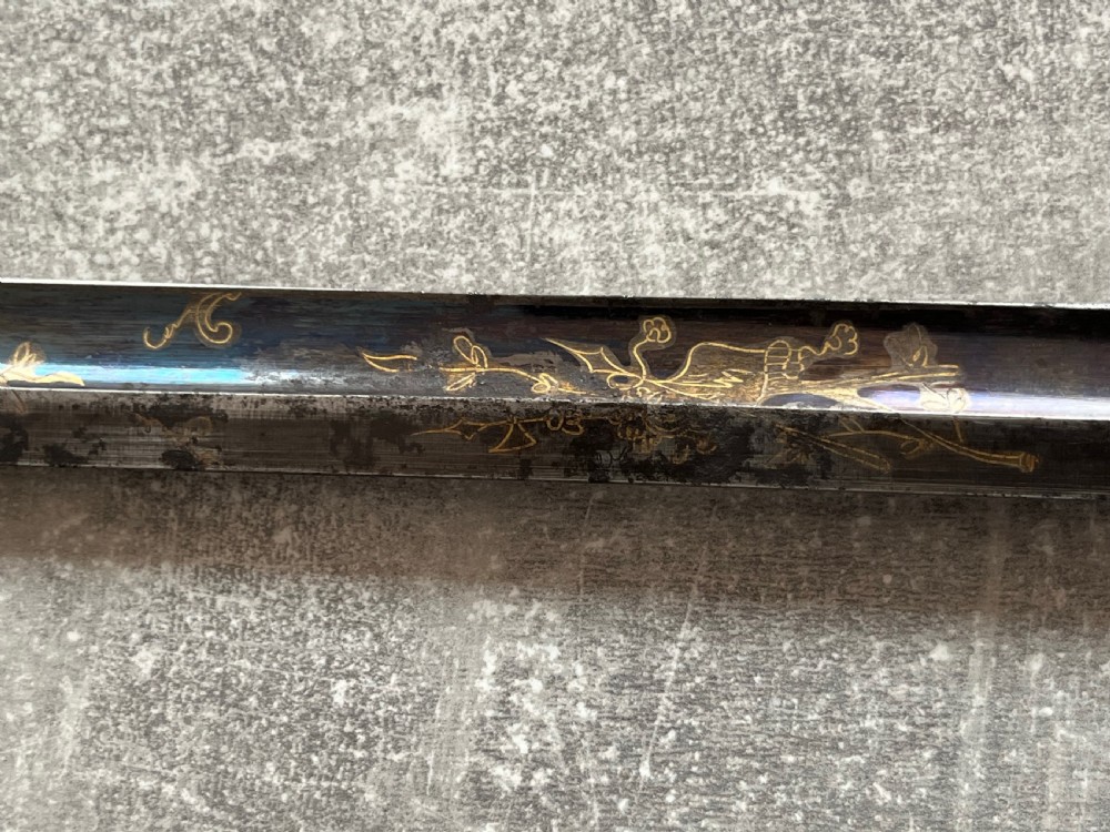 An antique sword stick with a dark brown leather-covered shaft, a silver knop top, and a partially drawn steel blade decorated with gold-toned etchings. View VI
