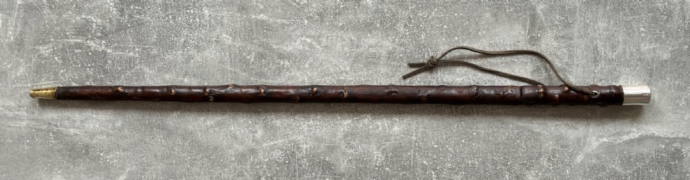 An antique sword stick with a dark brown leather-covered shaft, a silver knop top, and a partially drawn steel blade decorated with gold-toned etchings. View XVI
