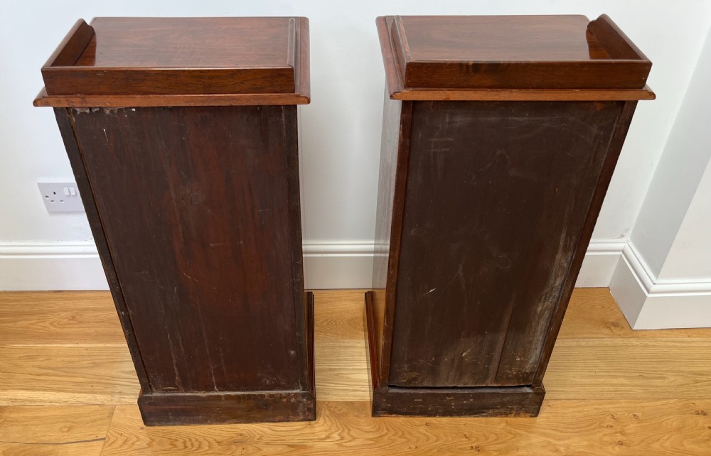 A pair of antique mahogany bedside cabinets featuring gallery tops, single panelled doors, brass drop handles, and solid plinth bases. View VIII