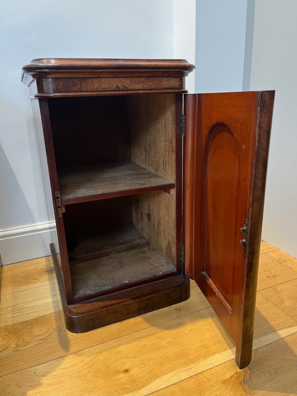 A matching pair of antique burr walnut bedside cabinets featuring single door cupboards with recessed arched panels and plinth bases. View VIII