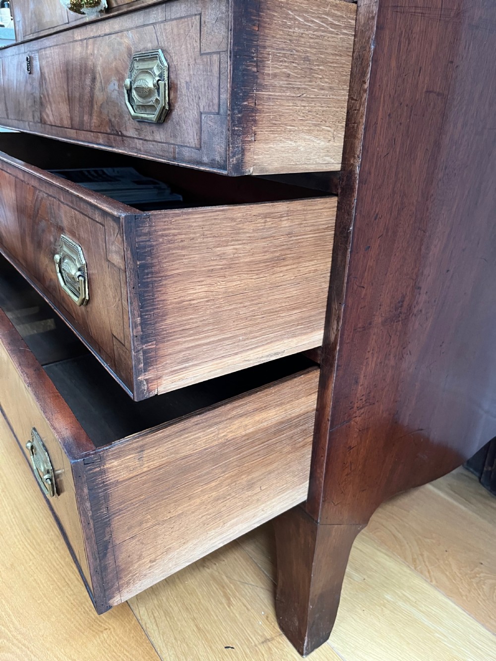 A Georgian mahogany secretaire bookcase featuring a double door upper cabinet with diamond astragal glazing, brass finials, and a lower chest of four drawers with brass drop handles. View XII