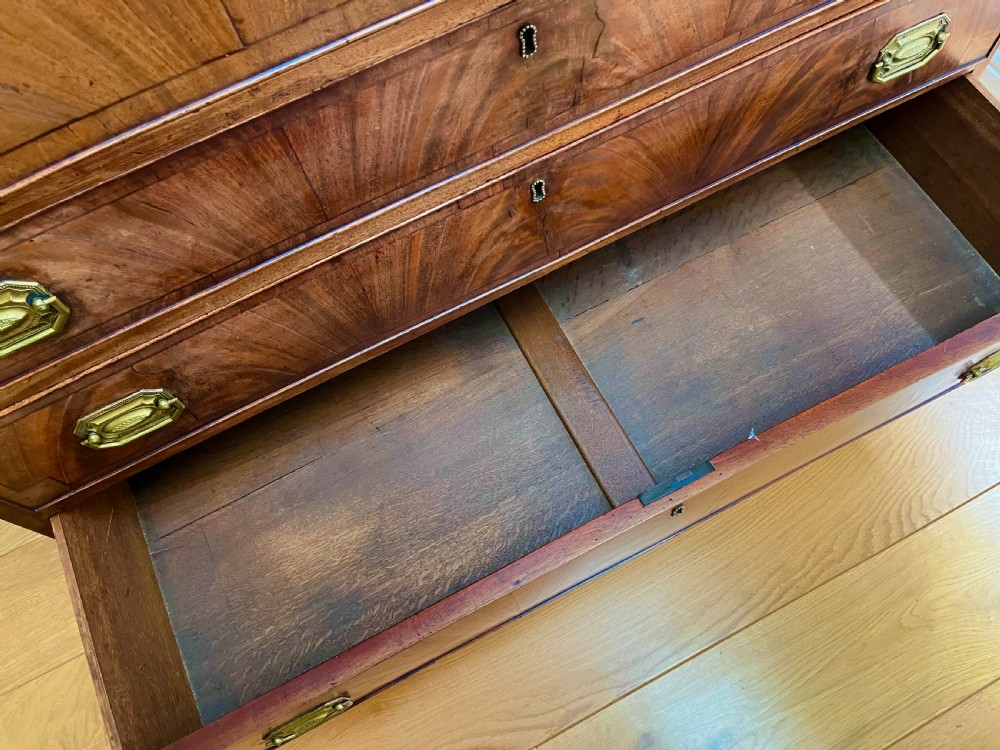 A Georgian mahogany secretaire bookcase featuring a double door upper cabinet with diamond astragal glazing, brass finials, and a lower chest of four drawers with brass drop handles. View XIV