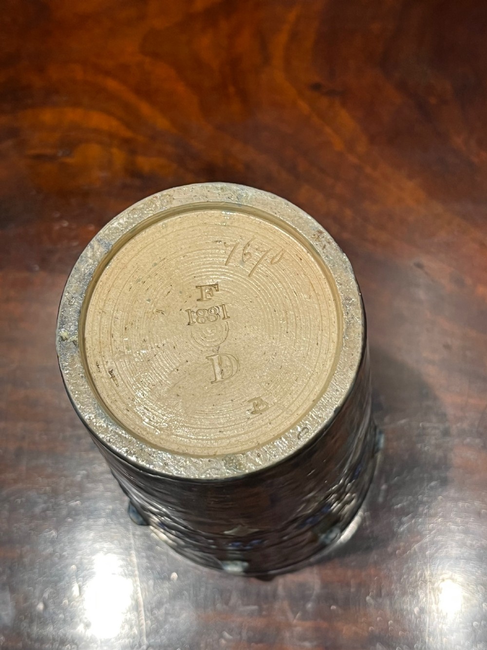 A Victorian Doulton Lambeth stoneware beaker featuring raised beaded scrollwork, floral motifs, and a hallmarked silver rim. View V