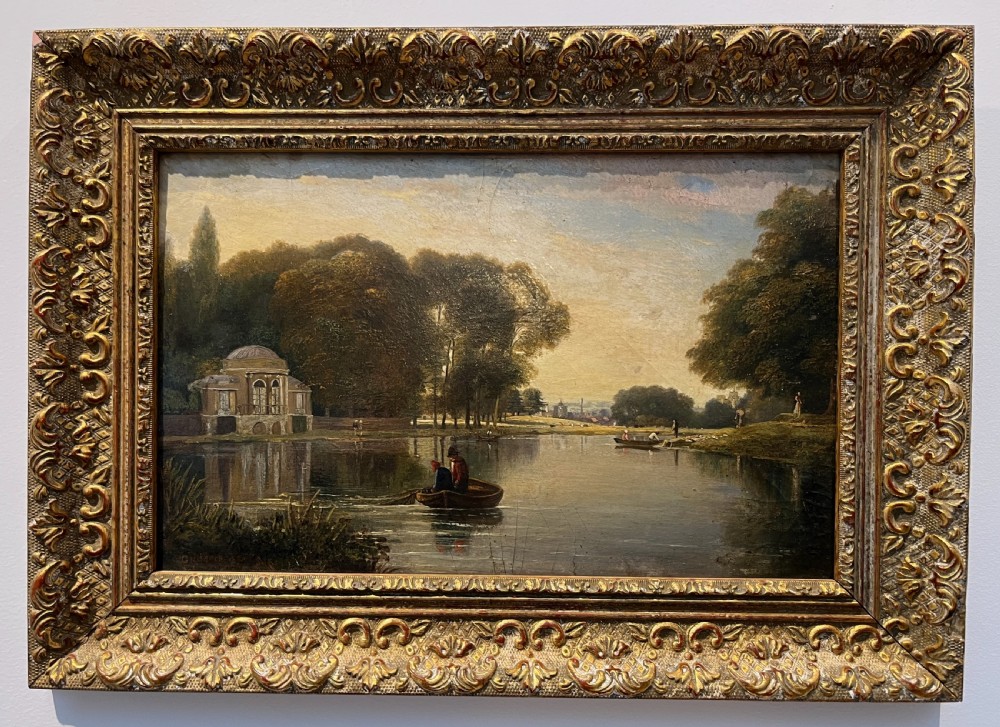 A 19th-century oil painting on board depicting figures in a rowboat on a calm river flanked by trees and classic architecture, housed in an ornate giltwood frame.