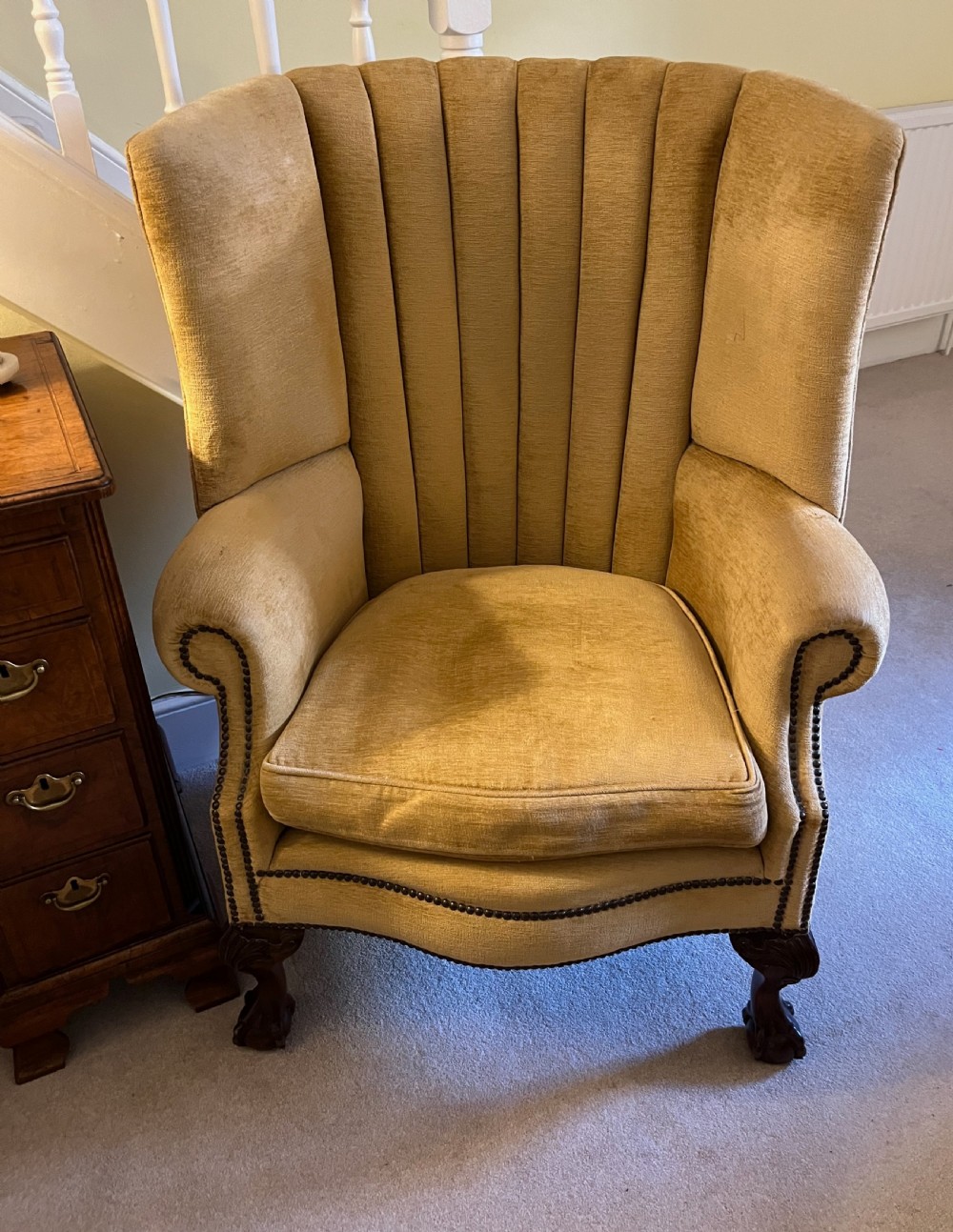 An Edwardian barrel back armchair upholstered in gold velvet with vertical fluted stitching, metal stud detailing, and carved dark wood legs. View III