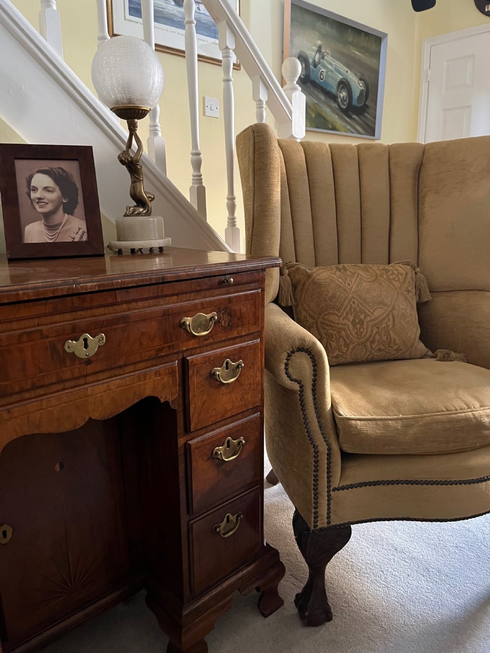 An Edwardian barrel back armchair upholstered in gold velvet with vertical fluted stitching, metal stud detailing, and carved dark wood legs. View VIII
