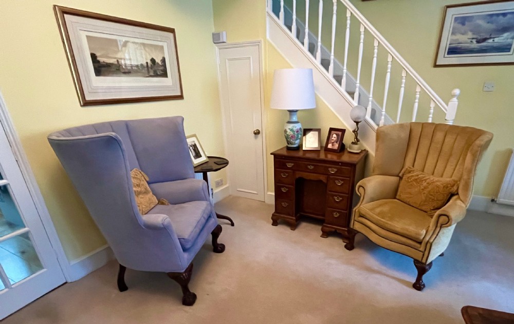 An Edwardian barrel back armchair upholstered in gold velvet with vertical fluted stitching, metal stud detailing, and carved dark wood legs. View XII