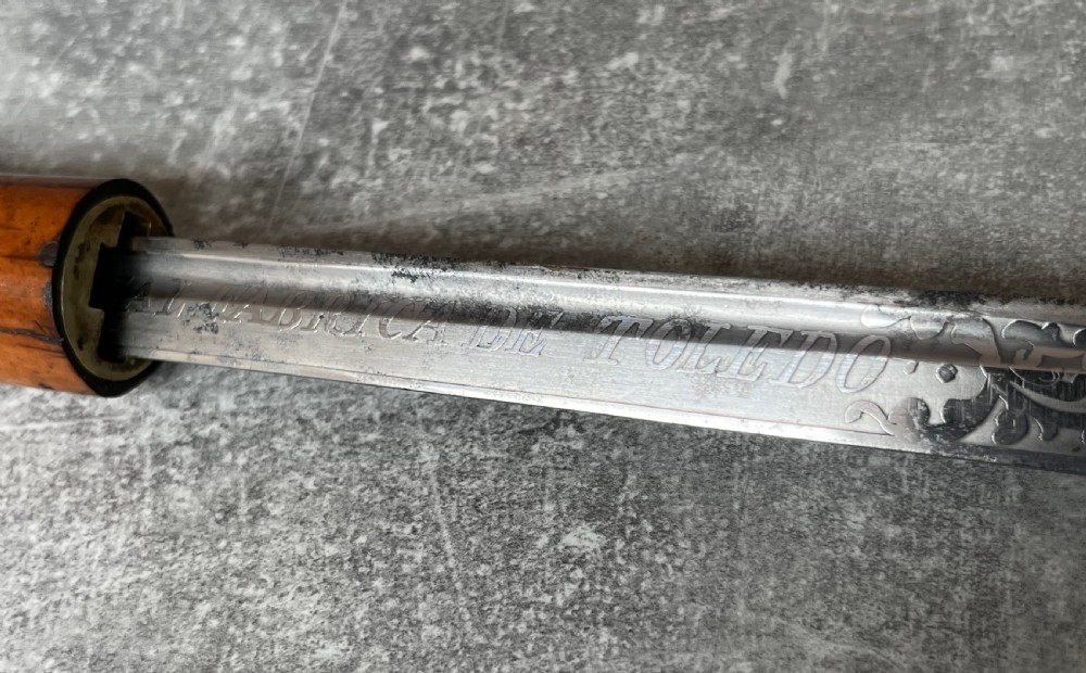 An antique Malacca wood walking stick unsheathed to reveal an etched steel Toledo blade alongside a silver collar and horn handle. View IV