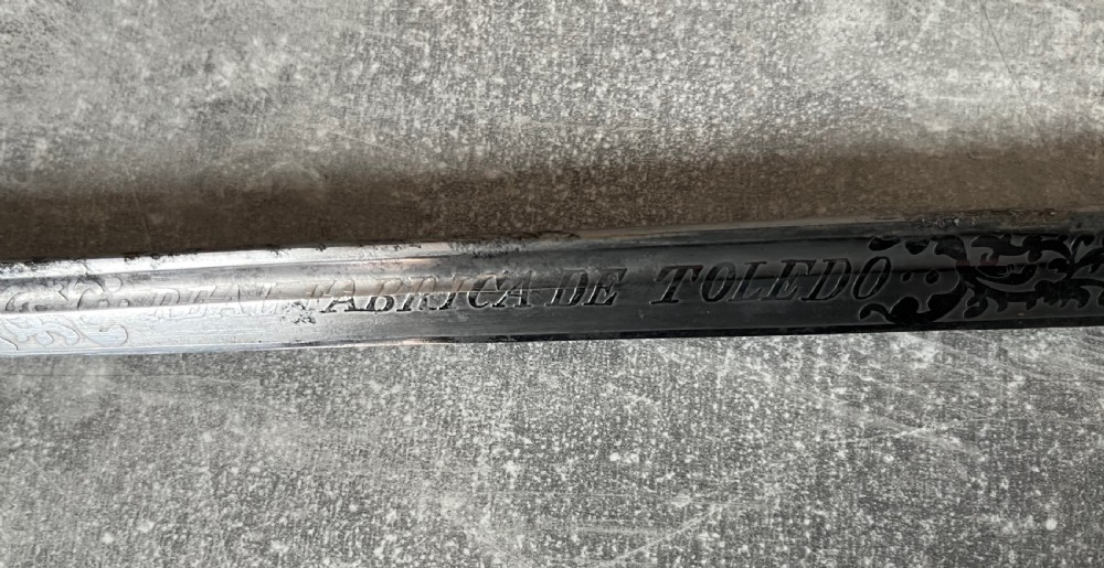 An antique Malacca wood walking stick unsheathed to reveal an etched steel Toledo blade alongside a silver collar and horn handle. View V