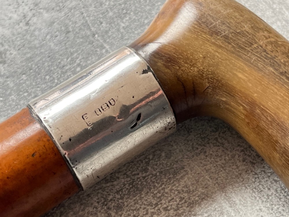An antique Malacca wood walking stick unsheathed to reveal an etched steel Toledo blade alongside a silver collar and horn handle. View VIII