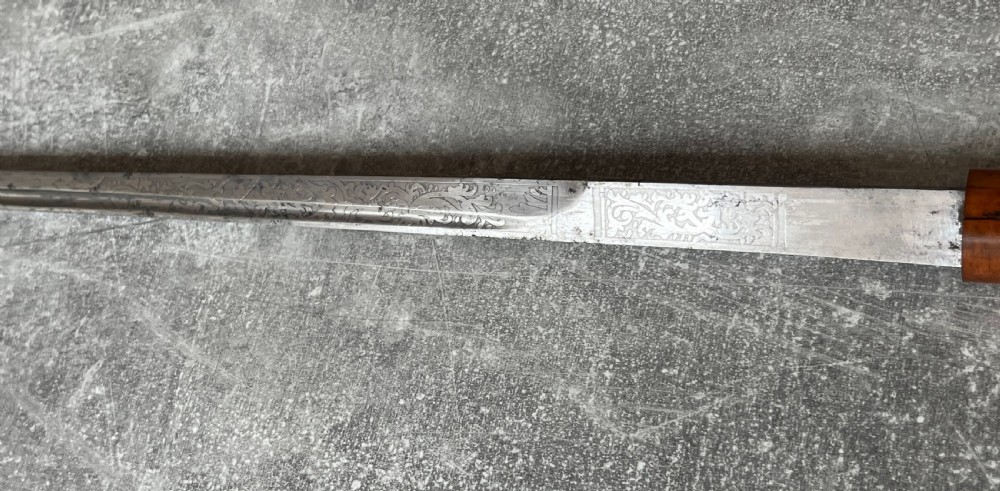 An antique Malacca wood walking stick unsheathed to reveal an etched steel Toledo blade alongside a silver collar and horn handle. View XII