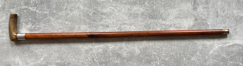 An antique Malacca wood walking stick unsheathed to reveal an etched steel Toledo blade alongside a silver collar and horn handle. View XV