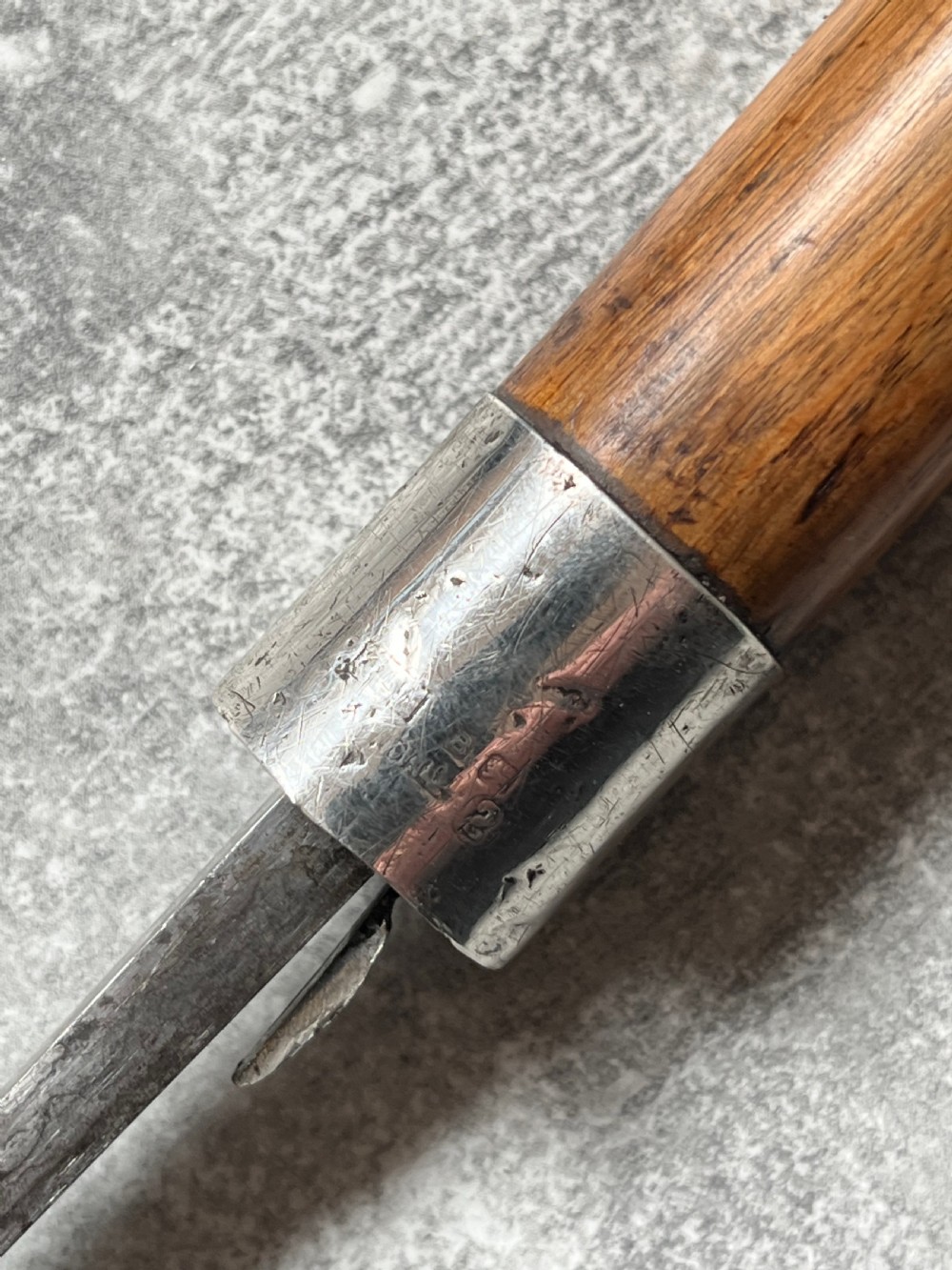 An antique crook-handled malacca walking cane unsheathed to reveal a long, slender steel sword blade beside its hollow wooden shaft. View VI