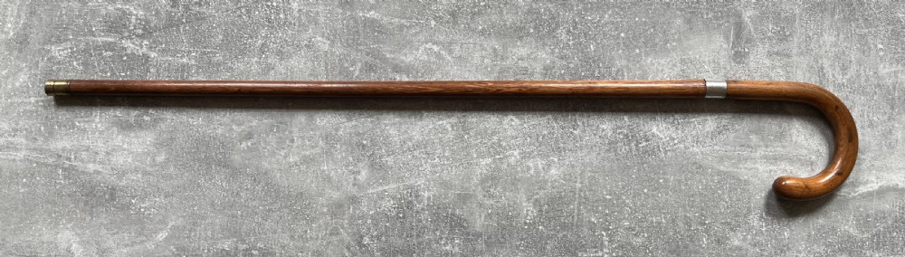 An antique crook-handled malacca walking cane unsheathed to reveal a long, slender steel sword blade beside its hollow wooden shaft. View XV
