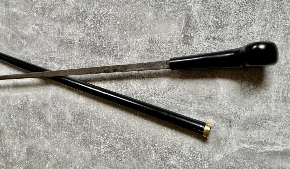 A Victorian ebonised wood walking stick shown in two parts alongside a slender concealed steel Toledo blade. View IX