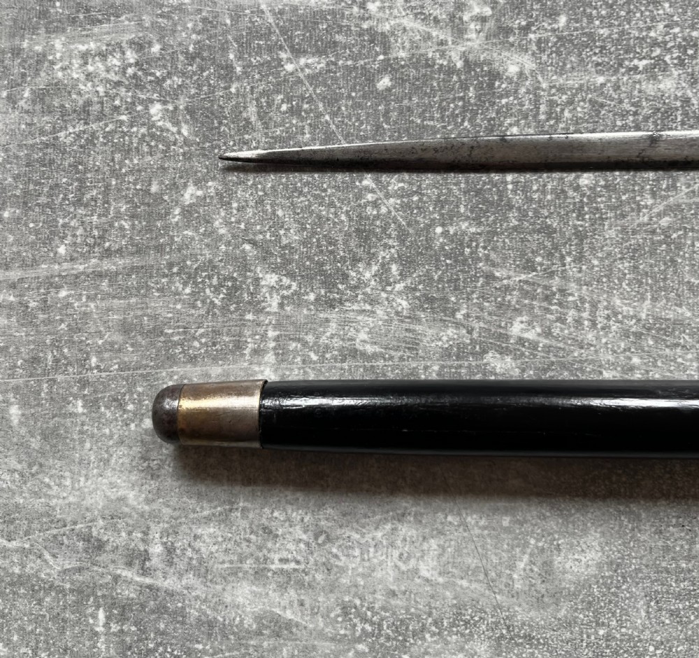 A Victorian ebonised wood walking stick shown in two parts alongside a slender concealed steel Toledo blade. View XI