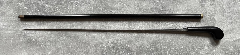A Victorian ebonised wood walking stick shown in two parts alongside a slender concealed steel Toledo blade. View XIV