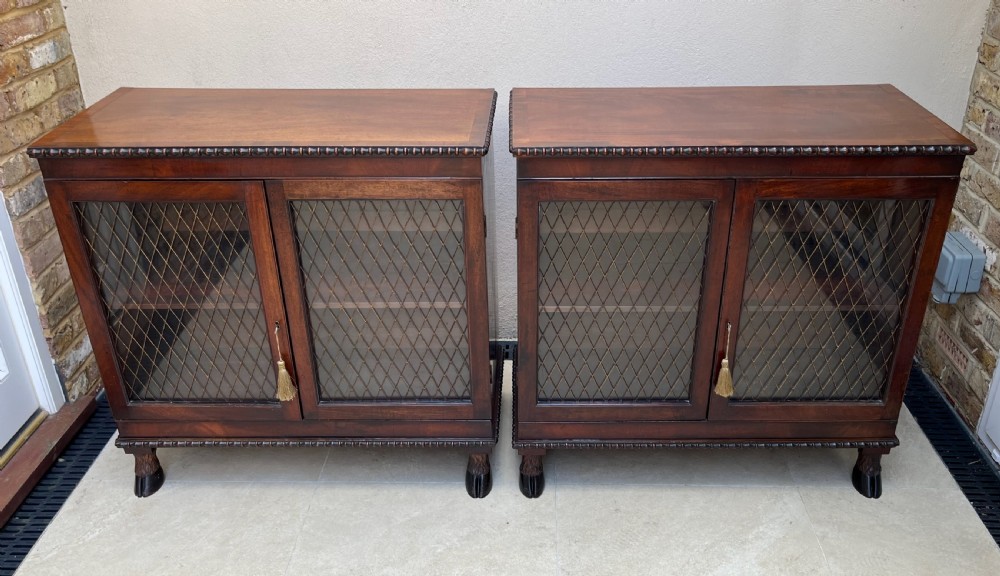 A pair of antique Regency mahogany side cabinets featuring brass lattice glazed doors and carved cloven hoof feet. View XIII