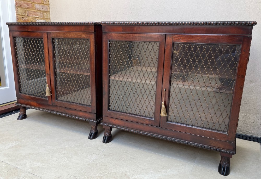 A pair of antique Regency mahogany side cabinets featuring brass lattice glazed doors and carved cloven hoof feet. View XIV