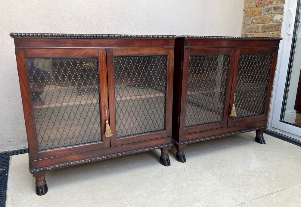 A pair of antique Regency mahogany side cabinets featuring brass lattice glazed doors and carved cloven hoof feet. View XV