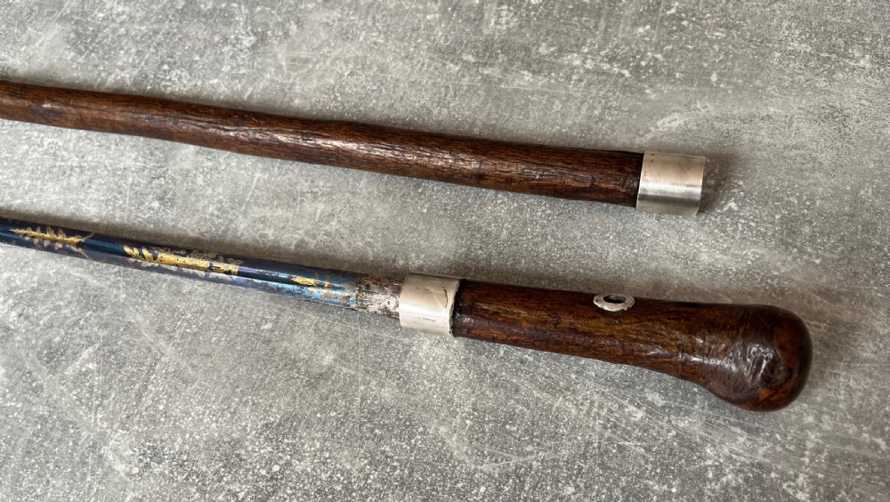 A late 19th-century dark hazel wood walking stick with a curved handle, silver collar, upper eyelet detail, and a metallic ferrule base. View VII