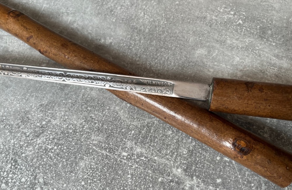 An antique hazel wood crook-handled walking stick shown unsheathed beside its concealed etched steel blade. View IV