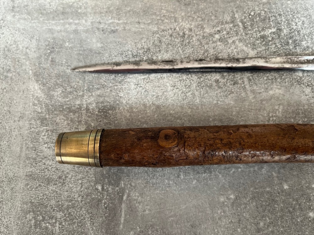 An antique hazel wood crook-handled walking stick shown unsheathed beside its concealed etched steel blade. View VI