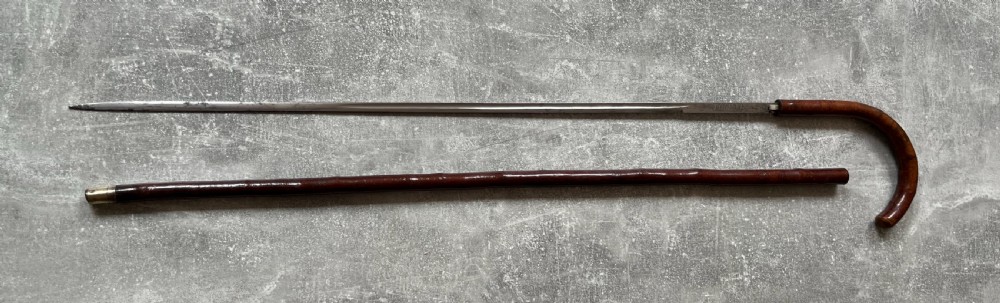 An antique cherrywood sword stick featuring a curved crook handle, a dark polished wood shaft, and a drawn steel blade with etched markings. View XIV