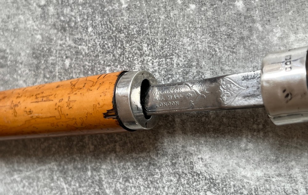 An antique malacca walking cane separated to reveal a tapered steel sword blade with silver and gold mounts. View VII