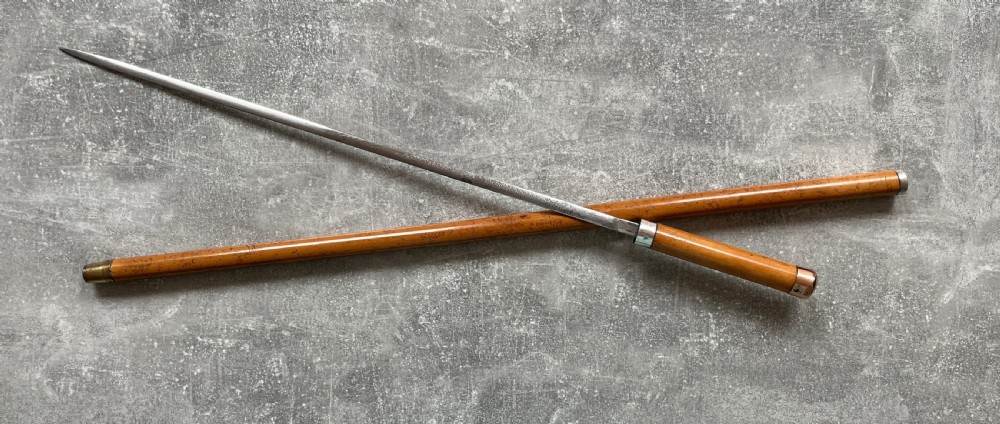 An antique malacca walking cane separated to reveal a tapered steel sword blade with silver and gold mounts. View XI