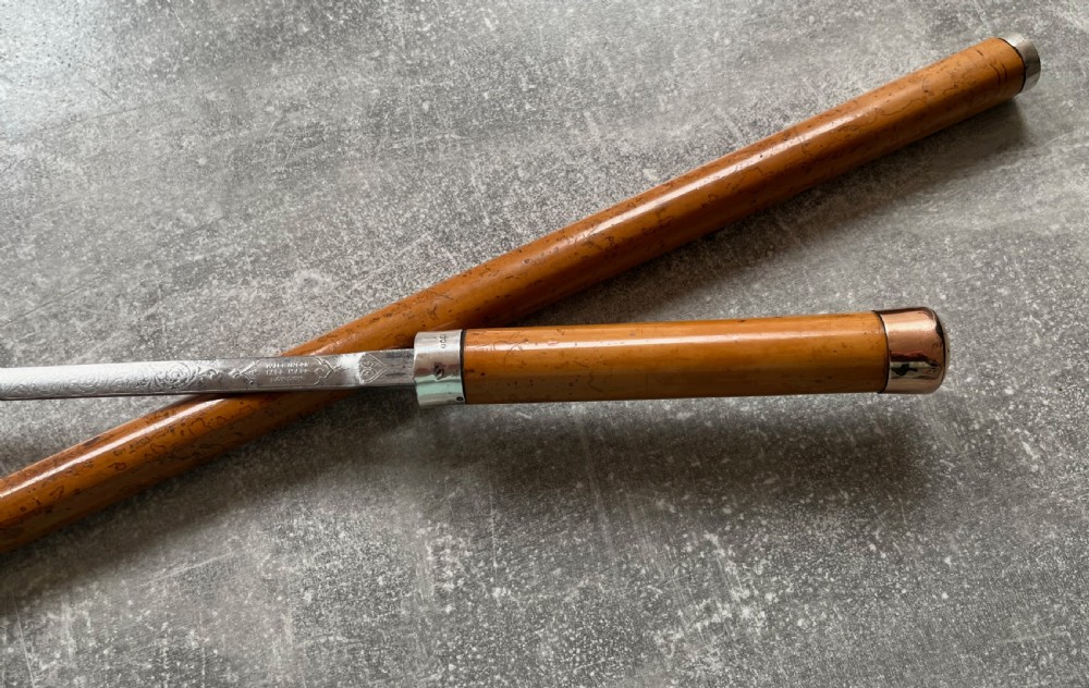 An antique malacca walking cane separated to reveal a tapered steel sword blade with silver and gold mounts. View XII