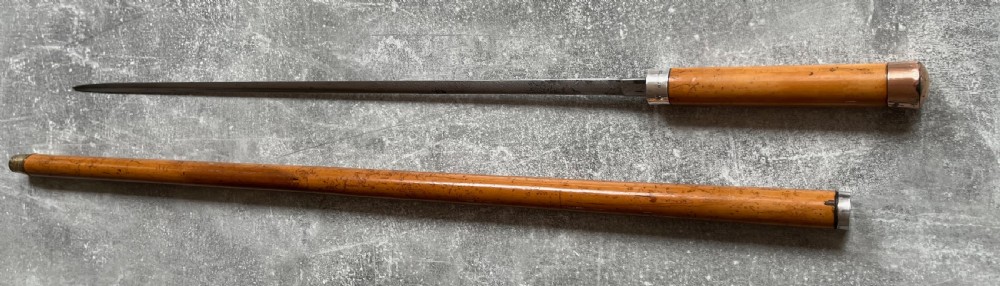 An antique malacca walking cane separated to reveal a tapered steel sword blade with silver and gold mounts. View XIII