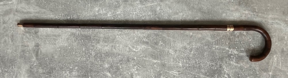 A dark wood walking stick featuring a crook handle and faux bamboo carved nodes, unsheathed to reveal a long steel blade alongside its wooden casing. View XV