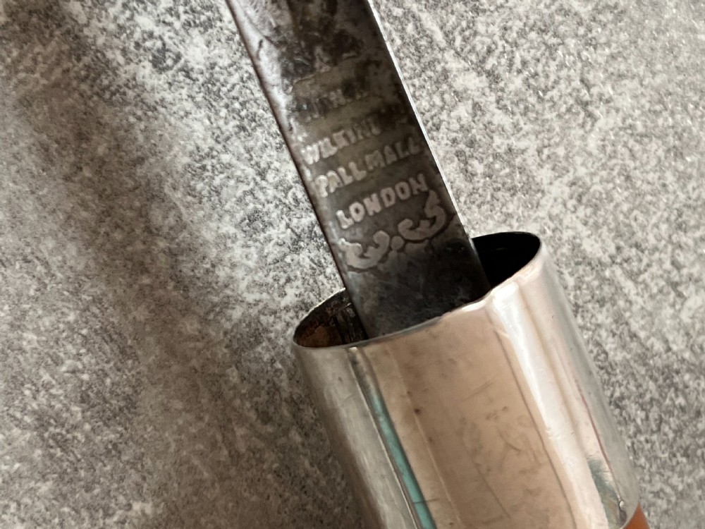 An antique malacca cane sword stick featuring a hallmarked silver pommel collar and an etched steel blade alongside its wooden sheath. View V