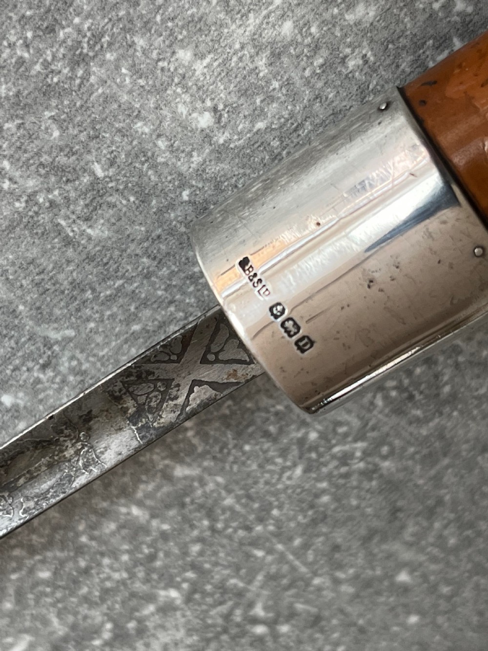 An antique malacca cane sword stick featuring a hallmarked silver pommel collar and an etched steel blade alongside its wooden sheath. View VI