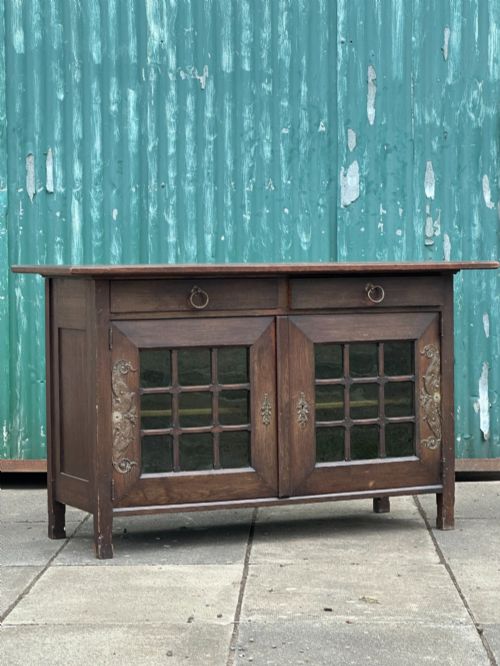 A CLASSY ARTS AND CRAFTS OAK SIDE CABINET ATTRIBUTED TO LIBERTY CO