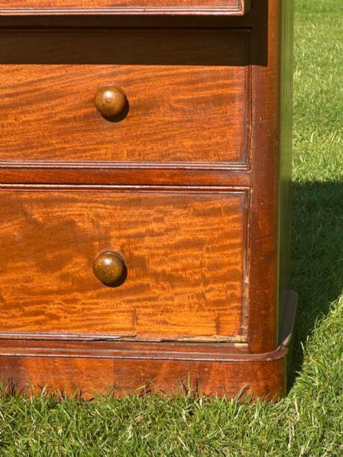 fig 1. A small Victorian flame mahogany Scotch chest of drawers with two short over two long drawers, turned wooden knobs, and a serpentine top.